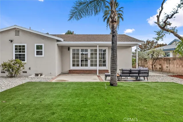 a view of a house with backyard and a tree