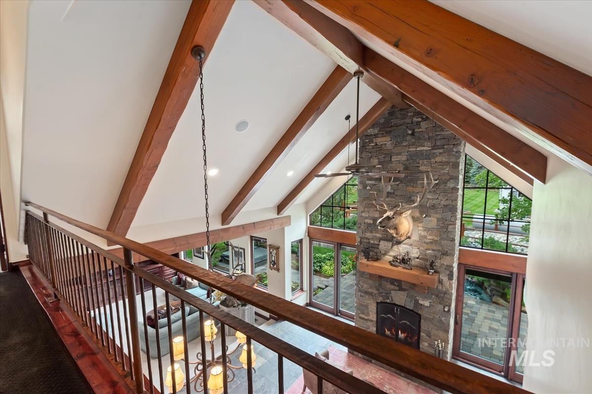 106 Hidden Hollow Road Hailey, ID 83333 - Photo 42 of 49 Vaulted ceiling with exposed wood beams, stone-clad fireplace, and expansive windows