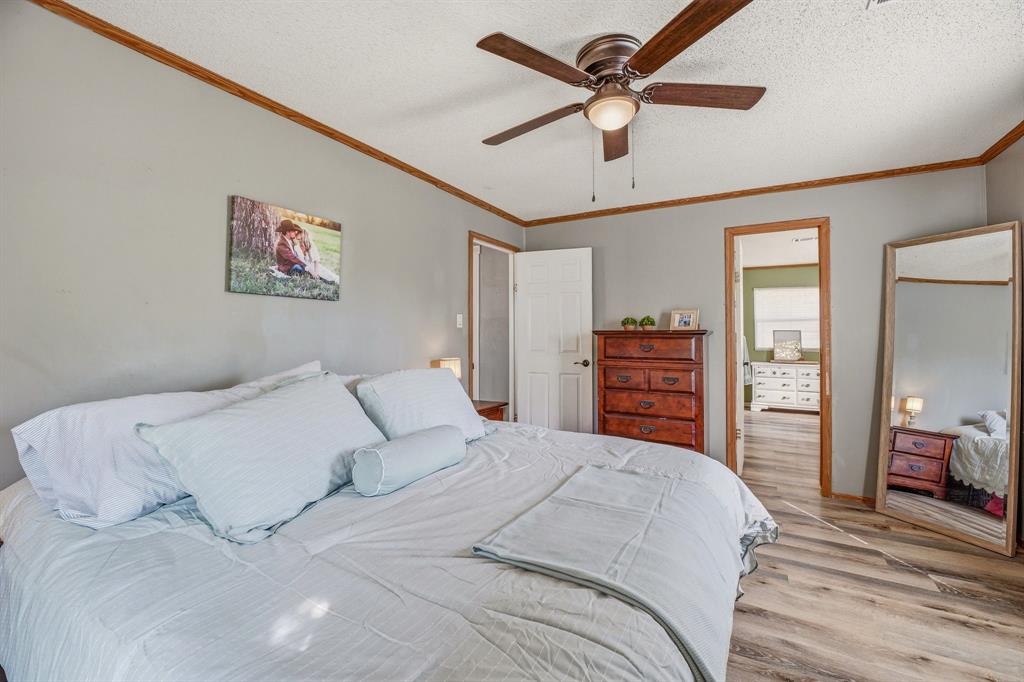 151 High Point Road Weatherford, TX 76088 - Photo 13 of 40 a bedroom with a large bed and a chandelier