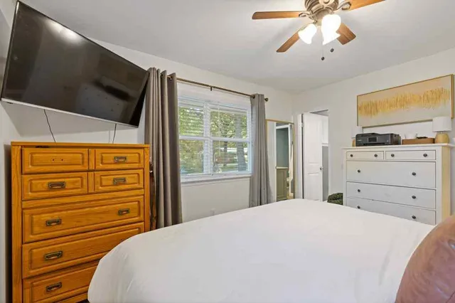 a bedroom with a bed and a flat tv screen on dresser