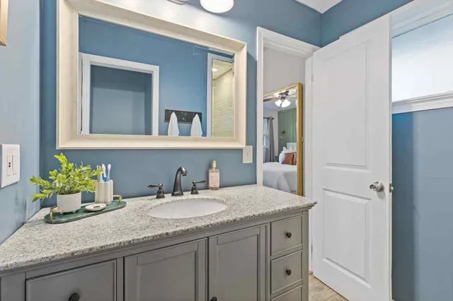 a bathroom with a granite countertop sink and a mirror