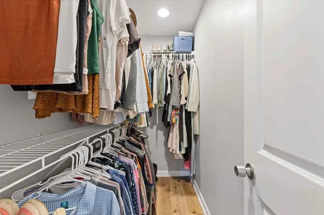 a view of walk in closet with clothes