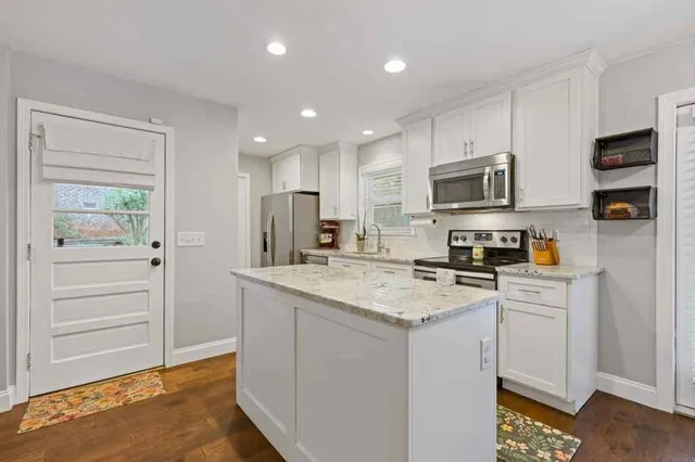 a kitchen with stainless steel appliances a stove refrigerator sink and cabinets