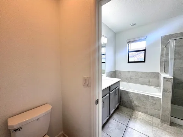 a bathroom with a granite countertop bathtub sink and toilet