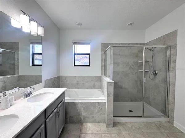 a bathroom with a bathtub shower sink vanity and toilet