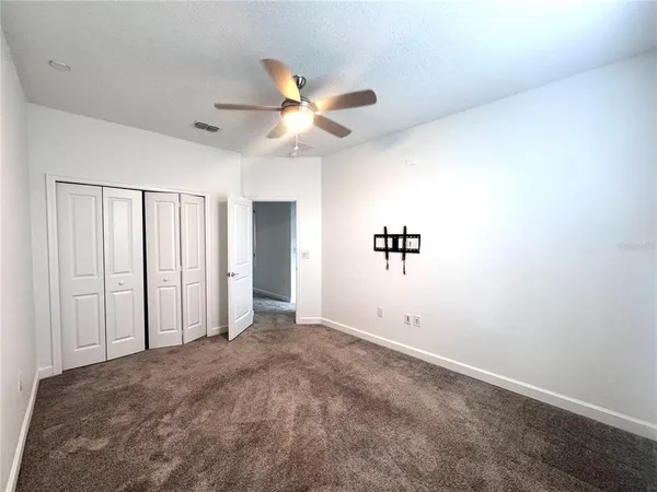 an empty room with closet and windows