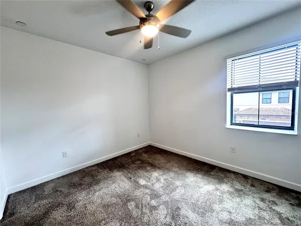 a view of a room with ceiling fan and window