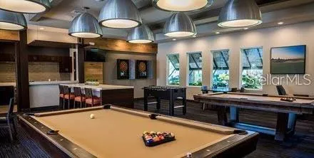 a room with furniture pool table and window