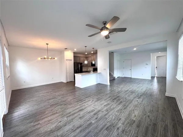 a view of a big room with wooden floor and a kitchen