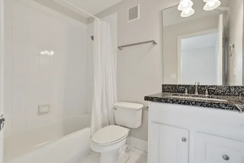a bathroom with a sink toilet vanity and shower