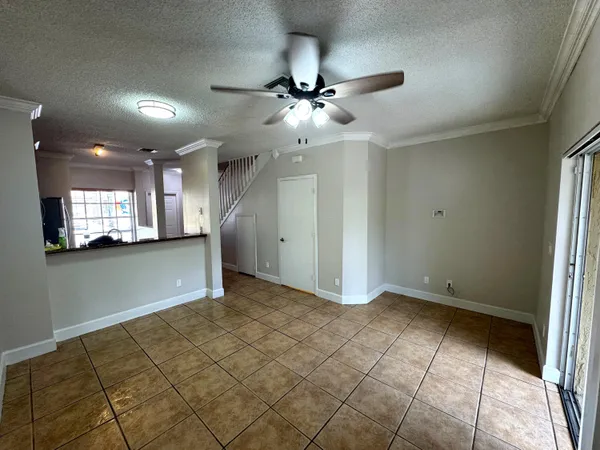 a view of an empty room and kitchen view