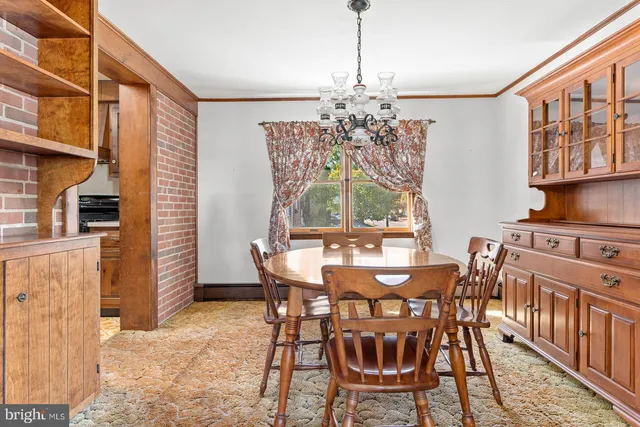 a view of a dining room with furniture and a chandelier