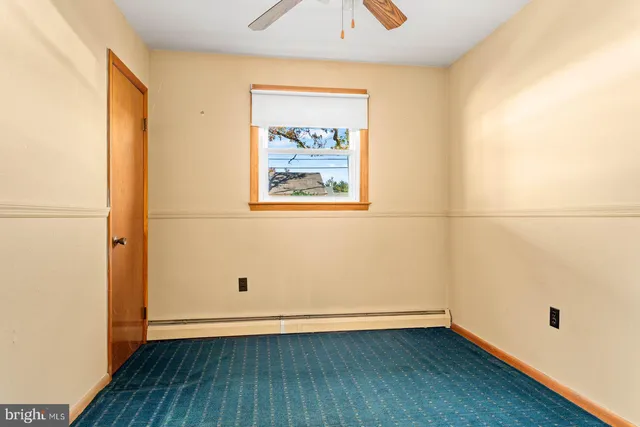 an empty room with wooden floor and window