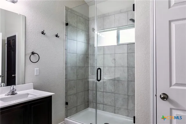 a bathroom with a shower sink and mirror