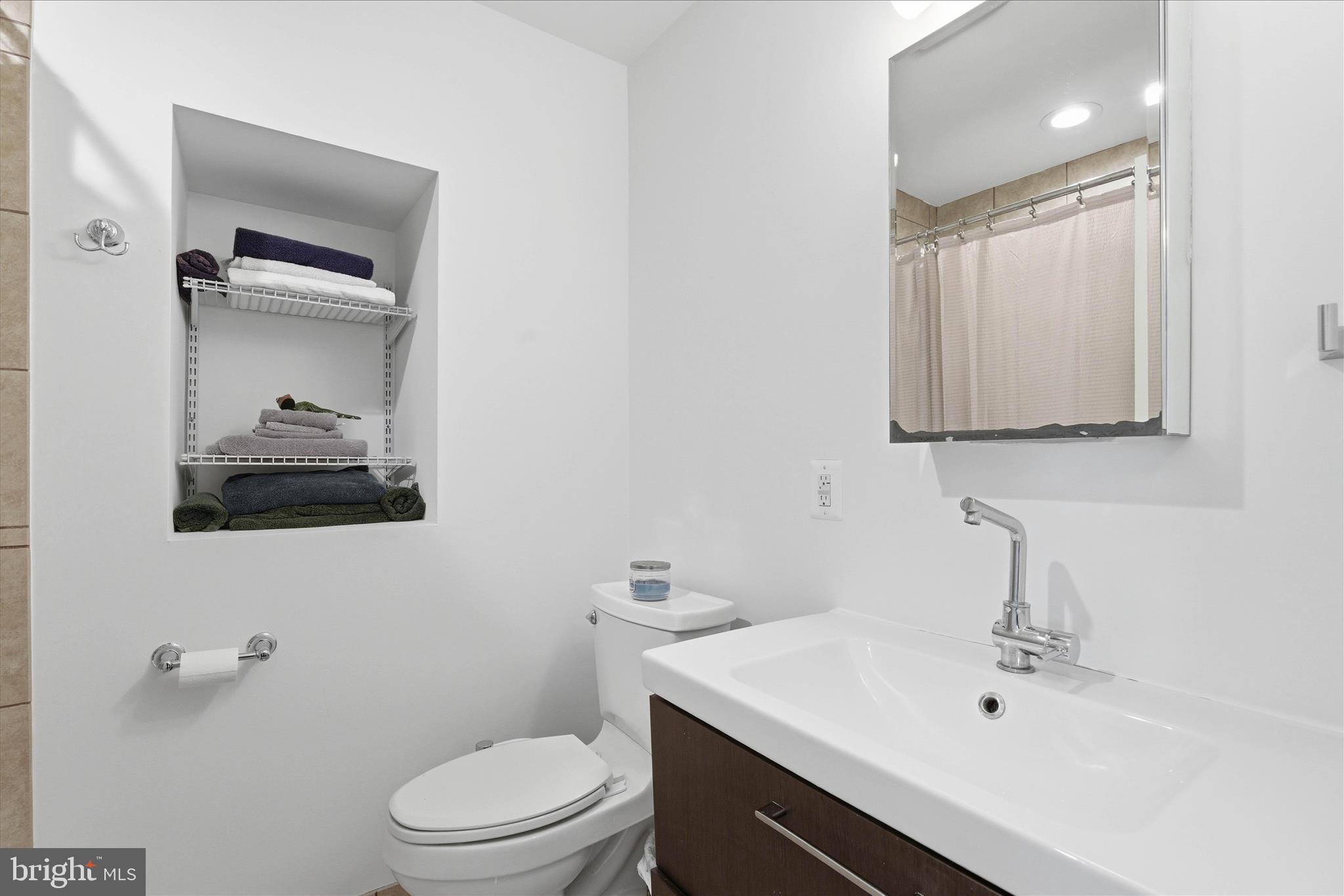 2510 Swift Run Street Vienna, VA 22180 - Photo 26 of 42 a bathroom with a sink a toilet and mirror