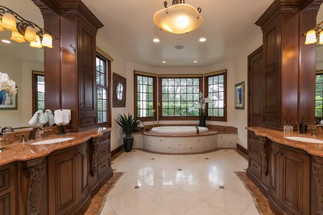 an aerial view of a house with a yard swimming pool and large trees