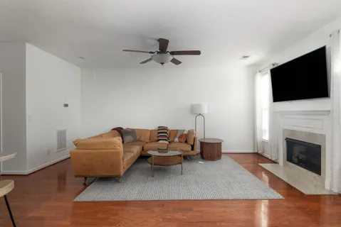 a living room with furniture a flat screen tv and a fireplace