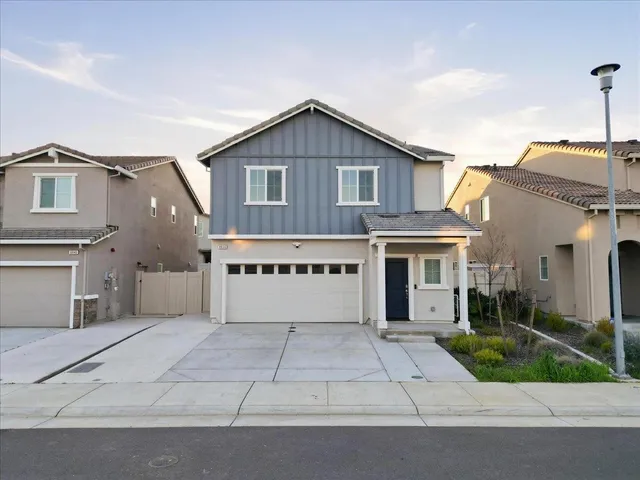 a view of a house with a yard and potted plants