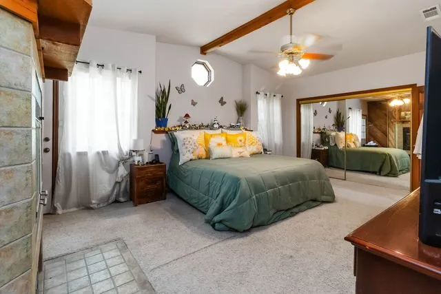 a bedroom with a bed and large mirror with window