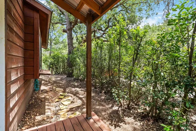 a view of backyard with wooden fence and large trees