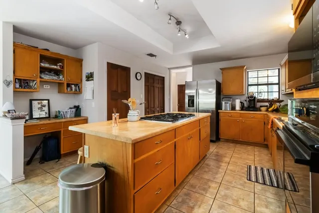 a large kitchen with stainless steel appliances granite countertop a sink and a stove