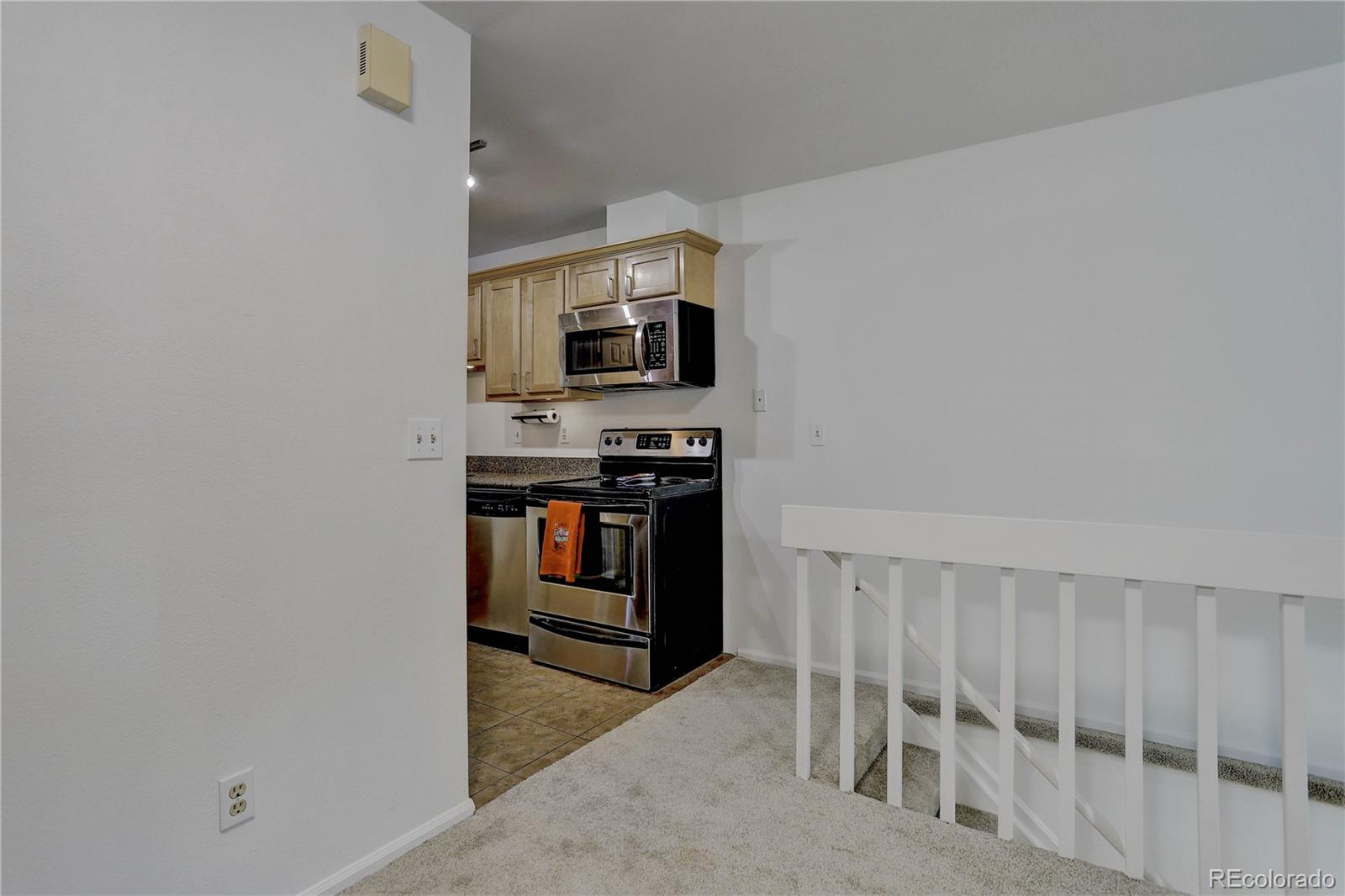 1885 South Quebec Way, Unit C15 Denver, CO 80231 - Photo 12 of 31 a kitchen with white cabinets and stainless steel appliances