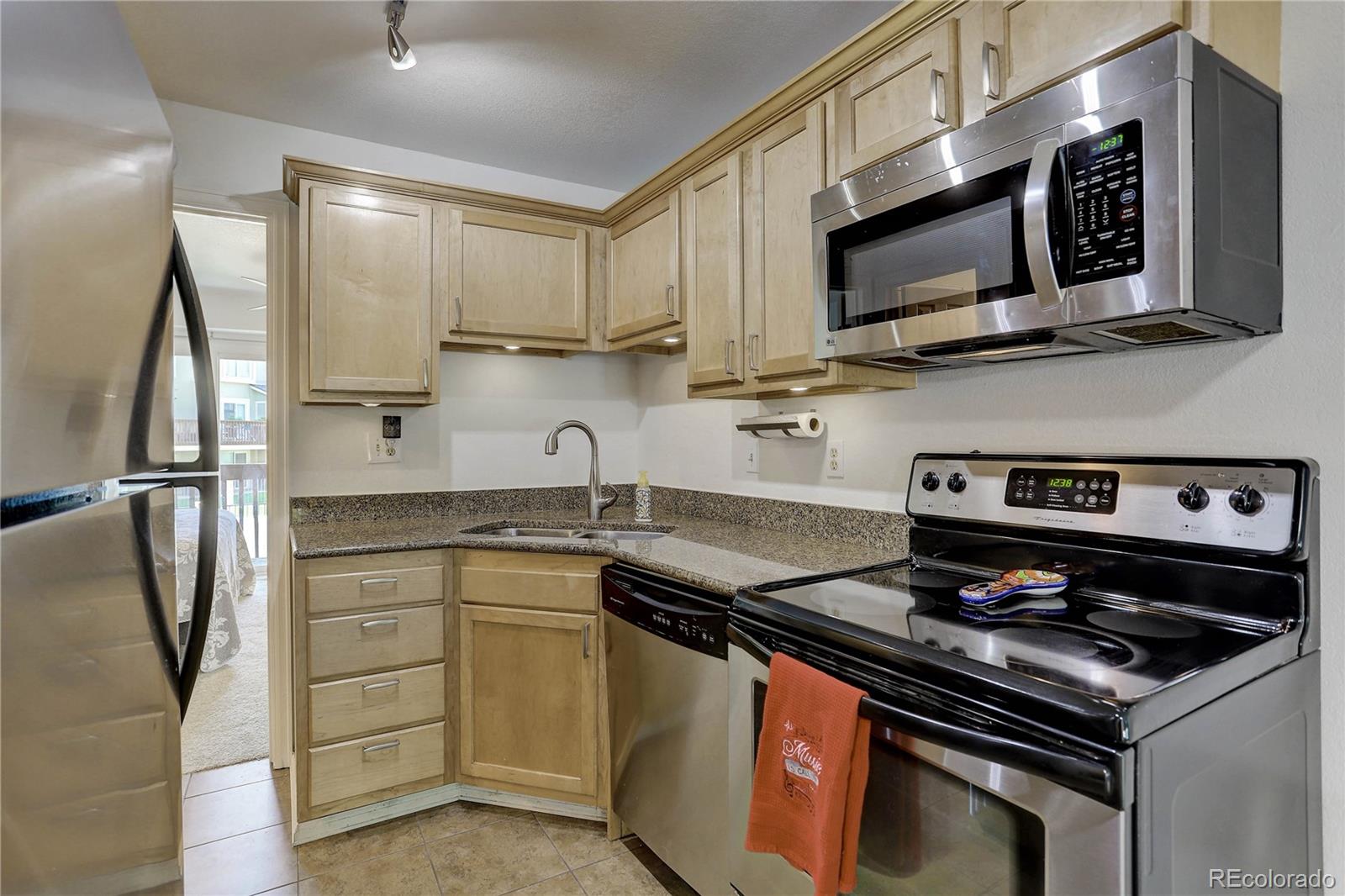 1885 South Quebec Way, Unit C15 Denver, CO 80231 - Photo 13 of 31 a kitchen with stainless steel appliances granite countertop a stove microwave and refrigerator