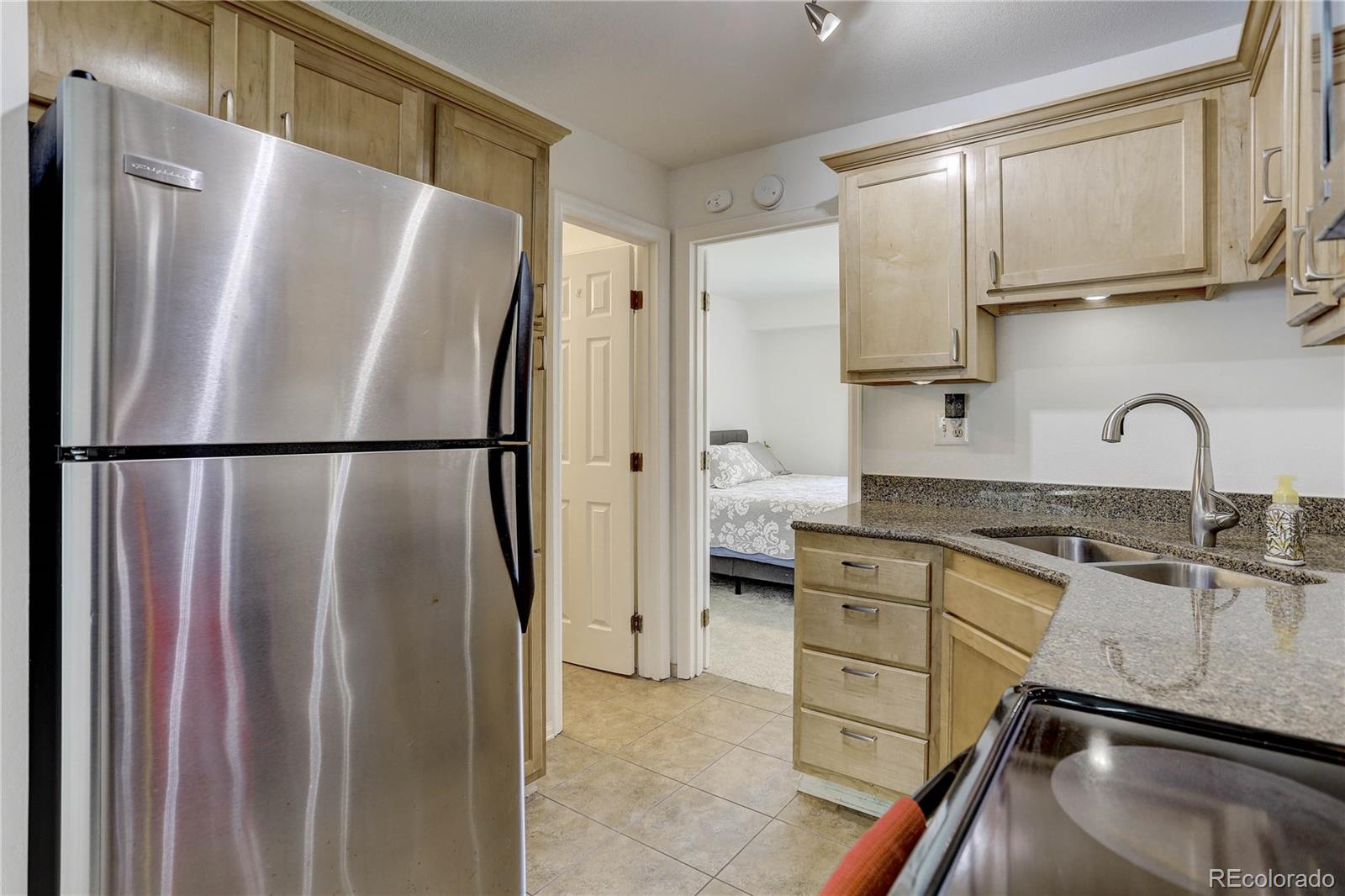 1885 South Quebec Way, Unit C15 Denver, CO 80231 - Photo 14 of 31 a kitchen with stainless steel appliances granite countertop a refrigerator and a sink