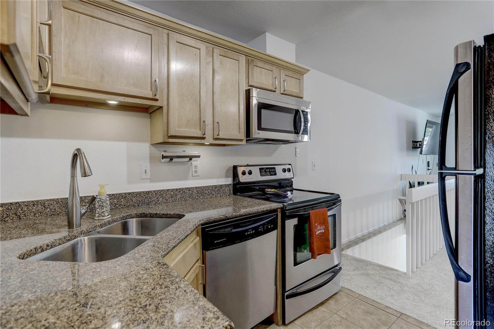 1885 South Quebec Way, Unit C15 Denver, CO 80231 - Photo 15 of 31 a kitchen with stainless steel appliances granite countertop a sink and a microwave