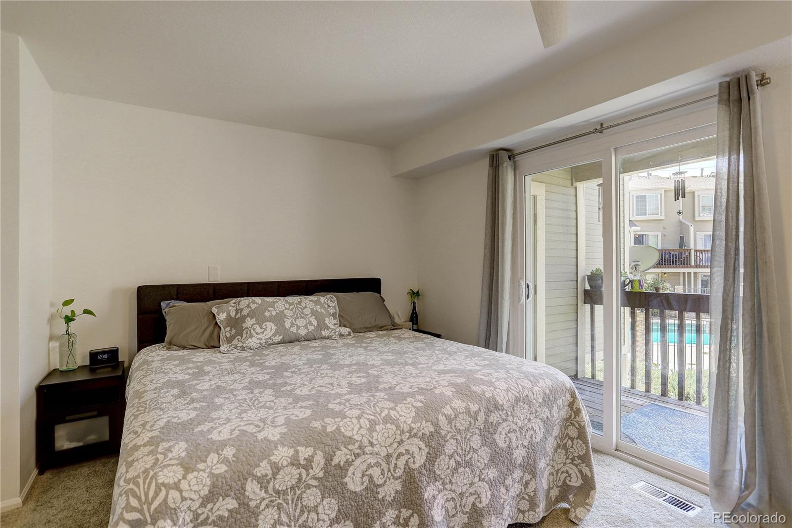 1885 South Quebec Way, Unit C15 Denver, CO 80231 - Photo 16 of 31 a bedroom with a large bed and a large window