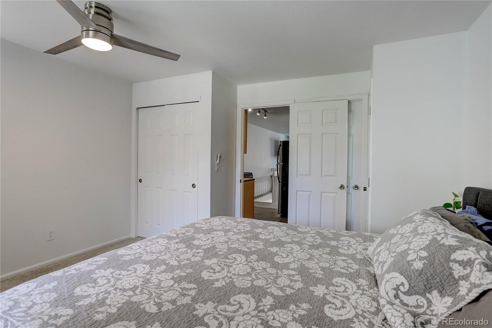 1885 South Quebec Way, Unit C15 Denver, CO 80231 - Photo 18 of 31 a bedroom with a bed and a chandelier fan