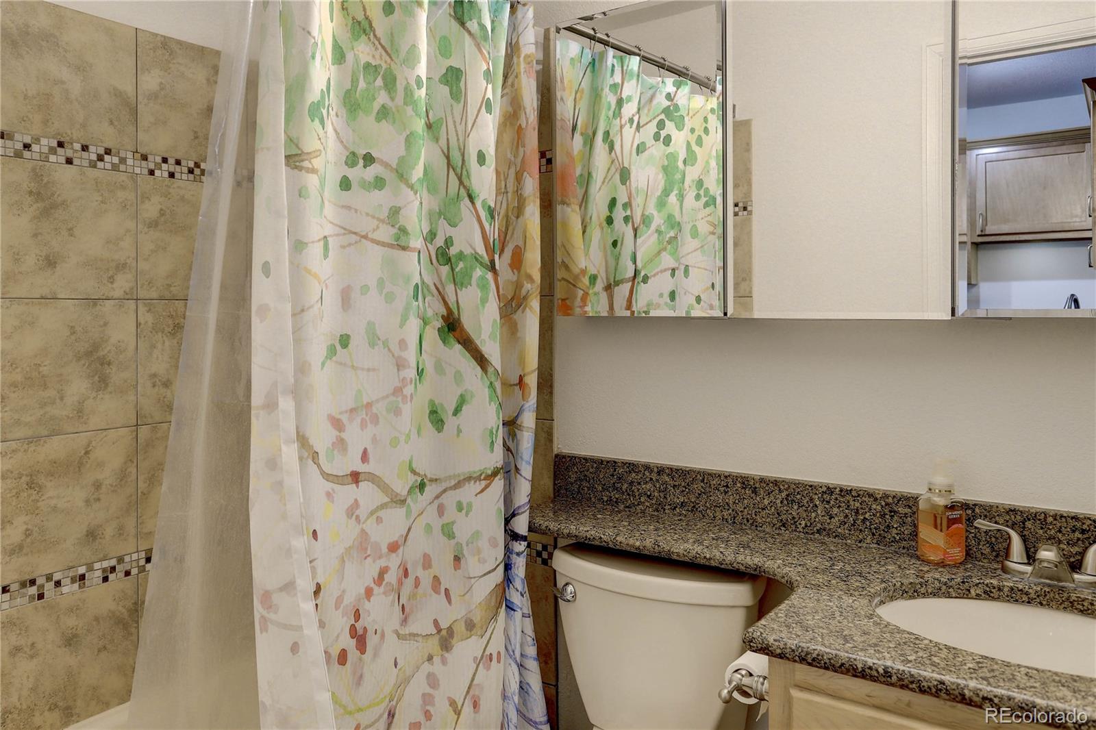 1885 South Quebec Way, Unit C15 Denver, CO 80231 - Photo 19 of 31 a bathroom with a granite countertop sink and a mirror