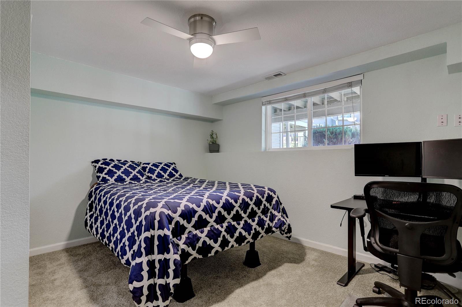1885 South Quebec Way, Unit C15 Denver, CO 80231 - Photo 25 of 31 a bedroom with bed and a flat tv screen on a dresser
