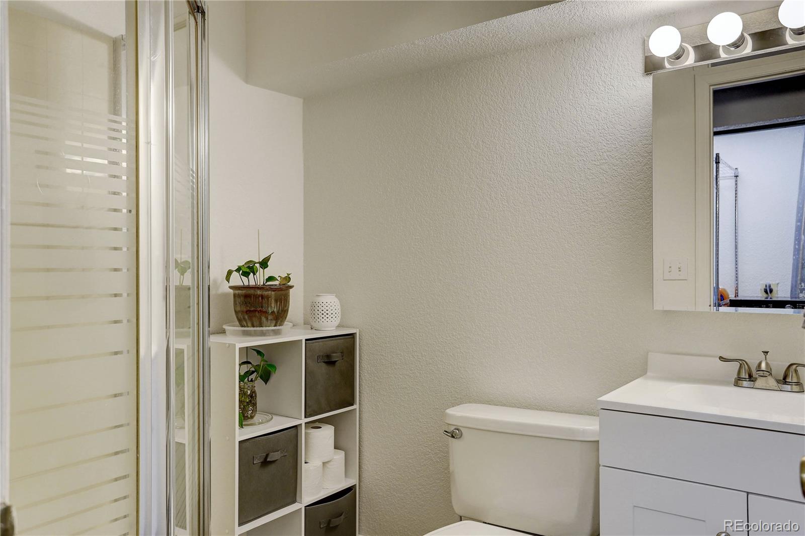 1885 South Quebec Way, Unit C15 Denver, CO 80231 - Photo 27 of 31 a bathroom with a sink a toilet and vanity
