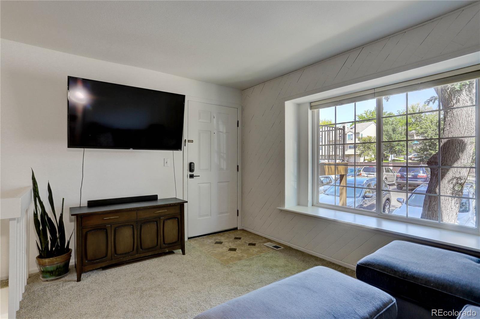 1885 South Quebec Way, Unit C15 Denver, CO 80231 - Photo 8 of 31 a living room with furniture and a flat screen tv