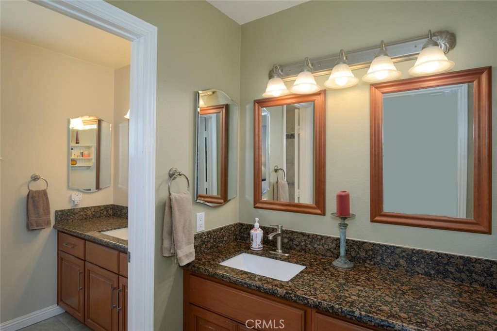 10424 Cartilla Court Rancho Cucamonga, CA 91737 - Photo 16 of 36 a bathroom with a granite countertop sink and a mirror