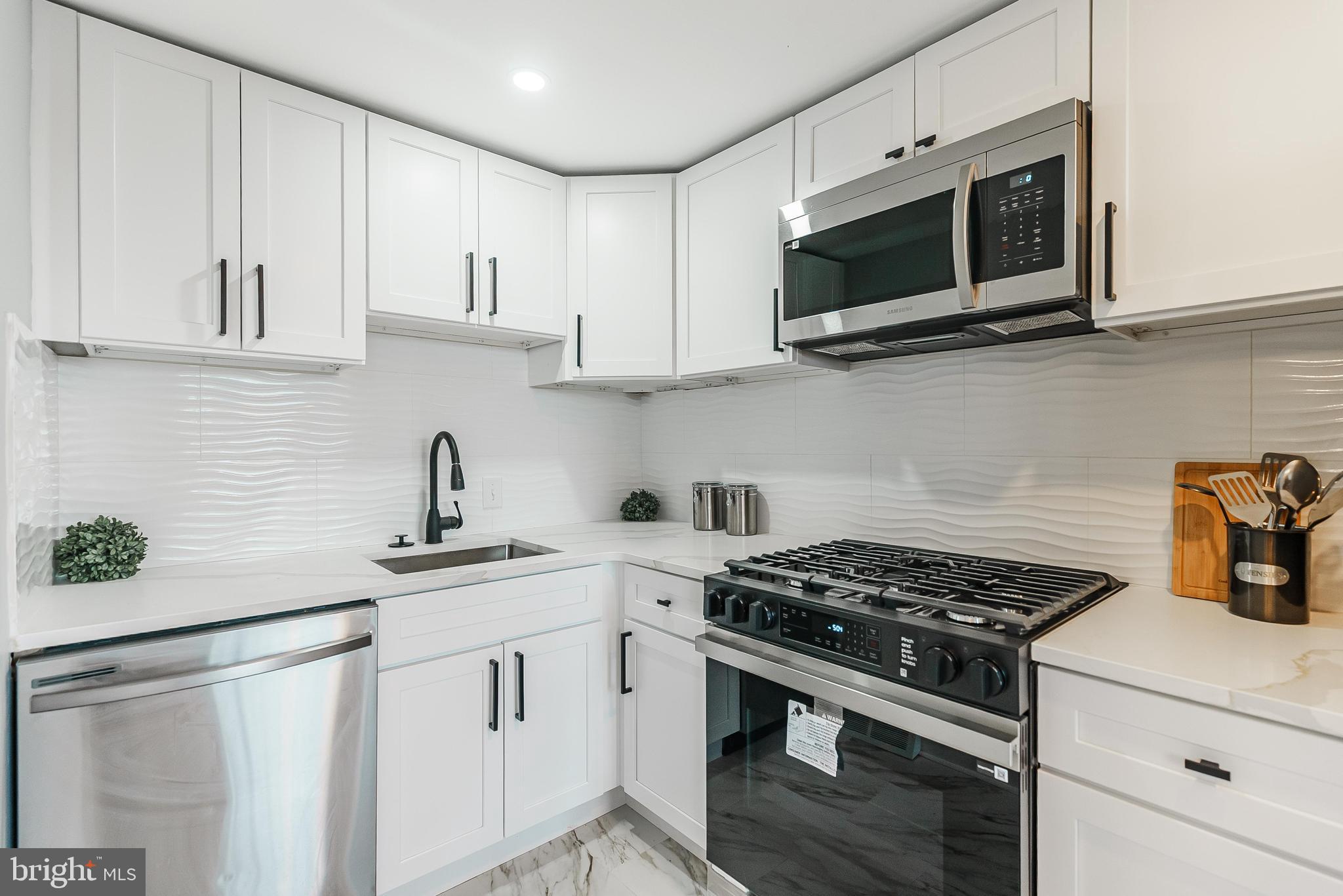 1620 Ashurst Road Philadelphia, PA 19151 - Photo 13 of 30 a kitchen with stainless steel appliances white cabinets and a stove top oven
