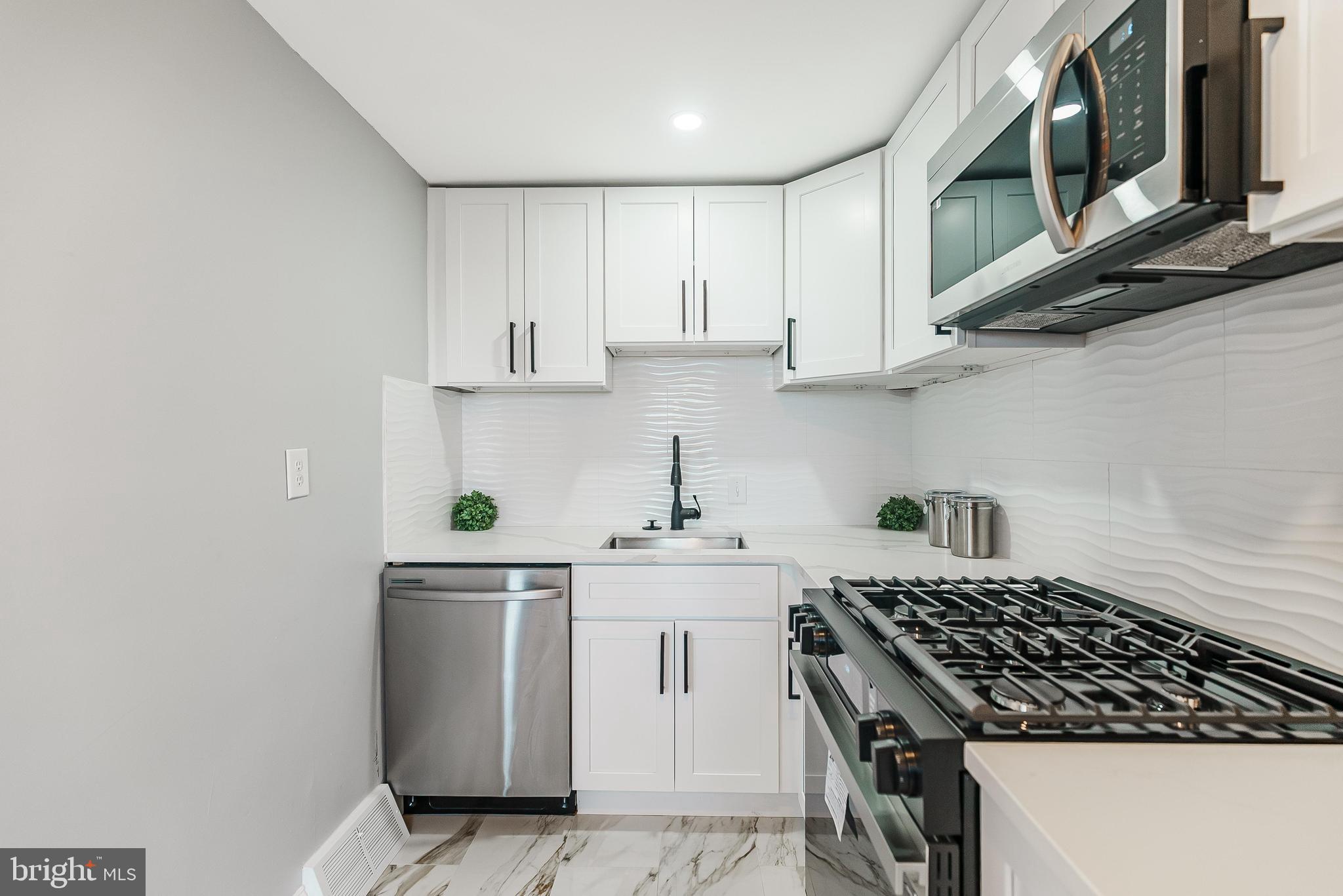 1620 Ashurst Road Philadelphia, PA 19151 - Photo 14 of 30 a kitchen with stainless steel appliances granite countertop a sink stove top oven and cabinets