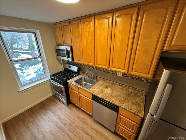 a kitchen with wooden floor and stainless steel appliances
