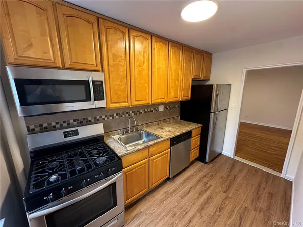 a kitchen with stainless steel appliances granite countertop a stove a refrigerator and a microwave