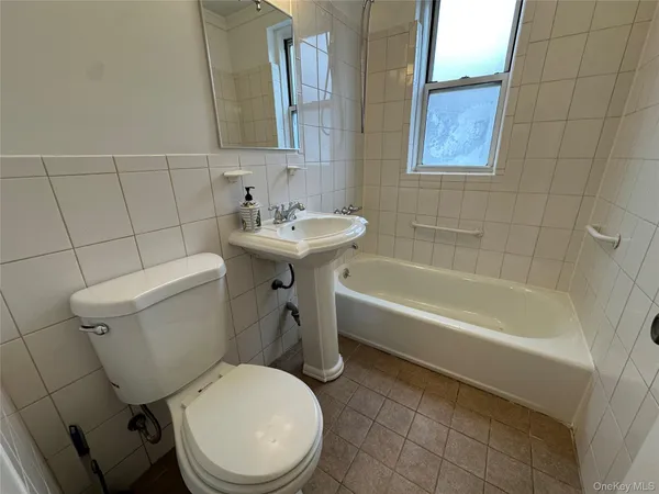 a white toilet sitting next to a bath tub