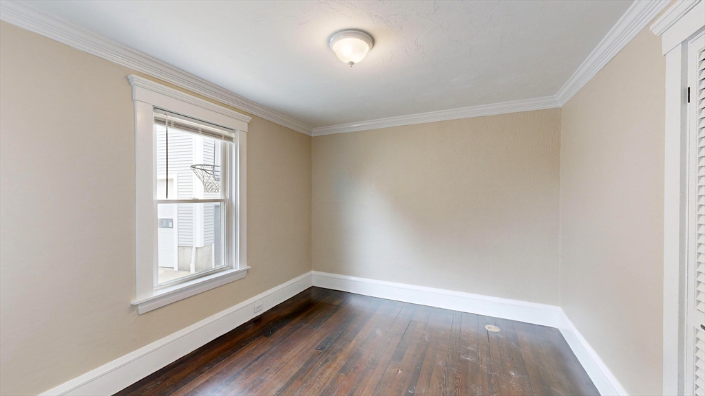 262 Plymouth Street, Unit 1 Bridgewater, MA 02324 - Photo 19 of 26 an empty room with wooden floor and windows