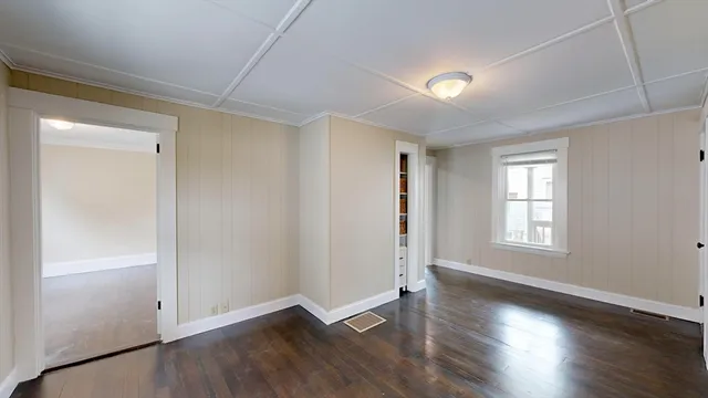 an empty room with wooden floor and window