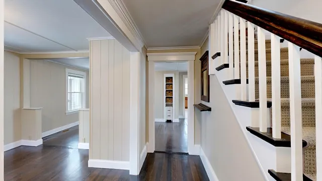 a view of a hallway with wooden floor and staircase