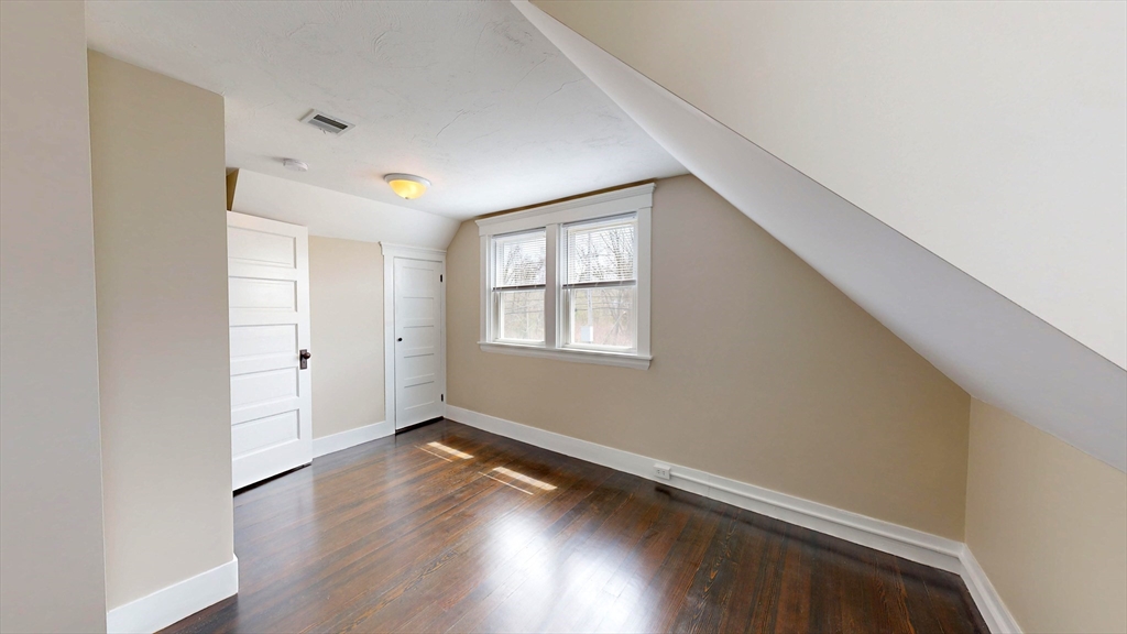 262 Plymouth Street, Unit 1 Bridgewater, MA 02324 - Photo 5 of 26 an empty room with wooden floor and windows