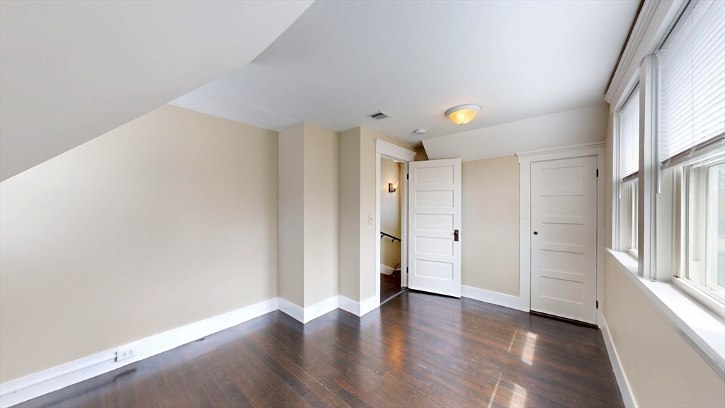 262 Plymouth Street, Unit 1 Bridgewater, MA 02324 - Photo 6 of 26 a view of an empty room with wooden floor and a window