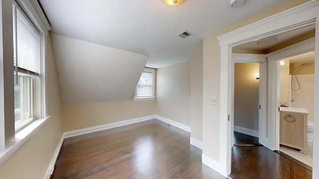a view of a room with wooden floor and window