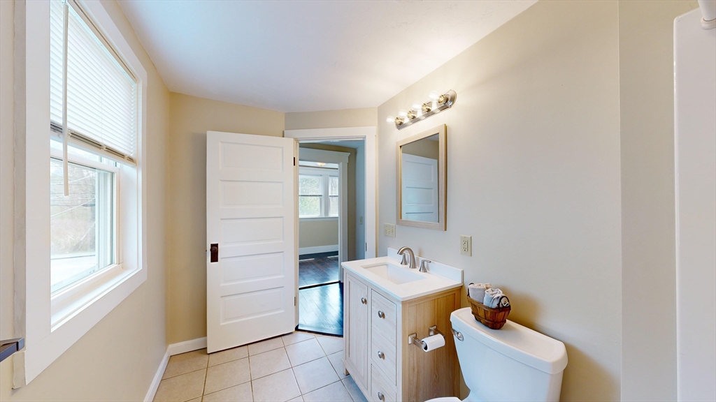 262 Plymouth Street, Unit 1 Bridgewater, MA 02324 - Photo 10 of 26 a bathroom with a sink toilet and mirror
