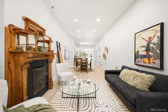 a living room with furniture a fireplace and a chandelier