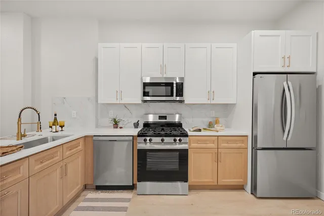a kitchen with white cabinets and stainless steel appliances